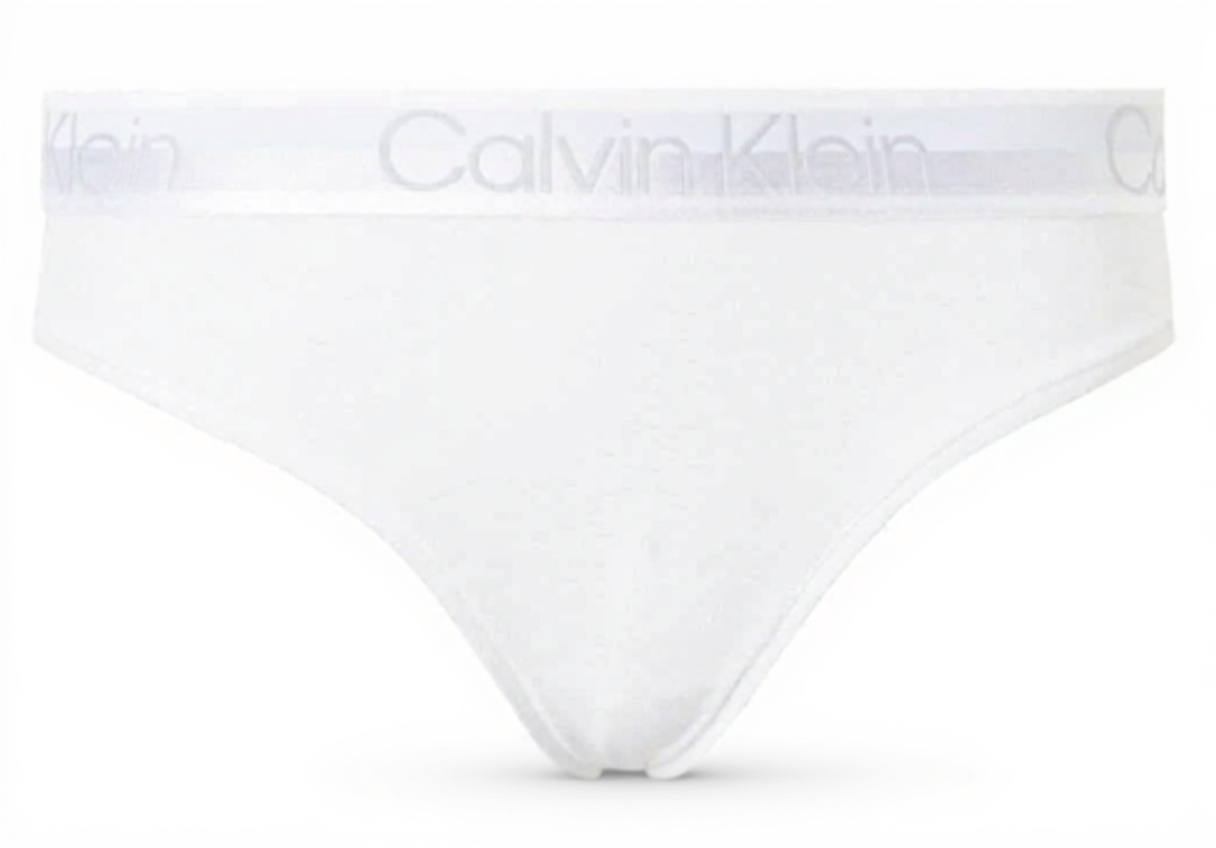 Femme portant le bikini blanc Calvin Klein, assise en bord de plage, démontrant la coupe et le style en situation réelle
